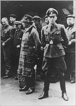 An SS officer stands in front of Jews assembled for deportation. Vienna, Austria, 1941-1942
